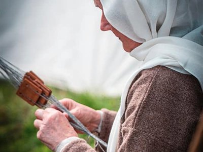 Reenactor weaving on a tablet loom