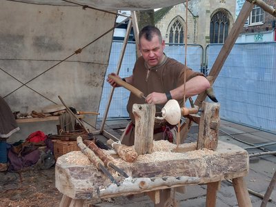 Reenactor turning a bowl on a pole lathe
